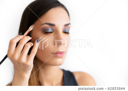 Make-up artist applying bright base color Make-up artist applying bright base color 62855844