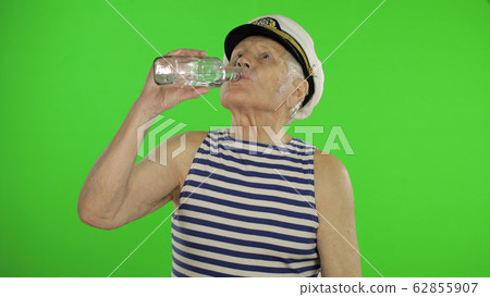 Elderly sailor man with mustache drinks vodka. Old sailorman on chroma key Elderly sailor man with mustache drinks vodka. Old sailorman on chroma key 62855907