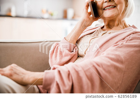 Senior woman talking on cellphone and smiling Senior woman talking on cellphone and smiling 62856189