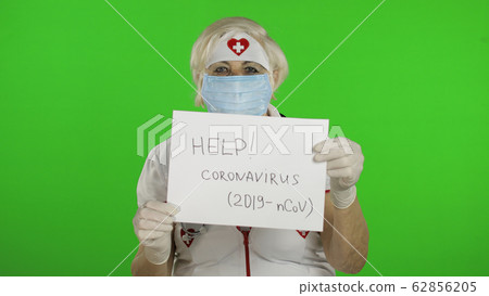 Elderly female doctor in medical mask show page with message. Coronavirus 62856205