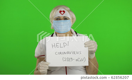 Elderly female doctor in medical mask show page with message. Coronavirus Elderly female doctor in medical mask show page with message. Coronavirus 62856207