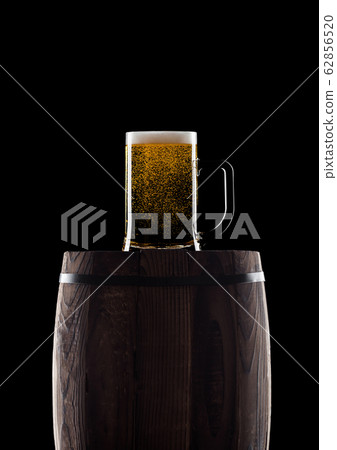 Cold glass of craft beer on old wooden barrel 62856520
