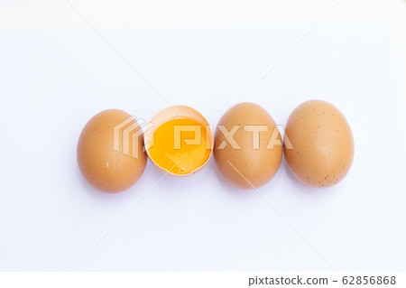 Four brown eggs arranged in a row on a white 62856868