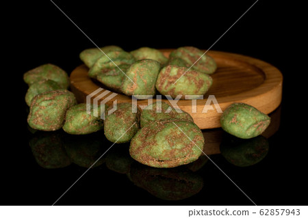 Green wasabi peanut isolated on black glass Green wasabi peanut isolated on black glass 62857943