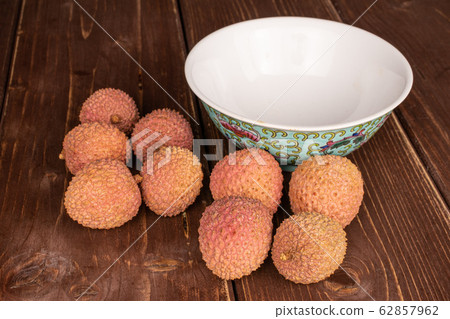 Fresh lychee fruit on brown wood 62857962