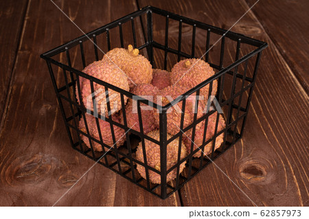 Fresh lychee fruit on brown wood Fresh lychee fruit on brown wood 62857973