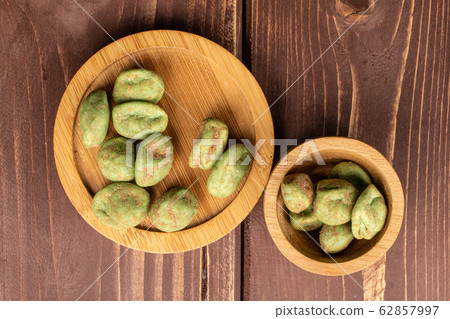 Green wasabi peanut on brown wood Green wasabi peanut on brown wood 62857997