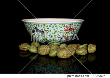 Green wasabi peanut isolated on black glass Green wasabi peanut isolated on black glass 62858048