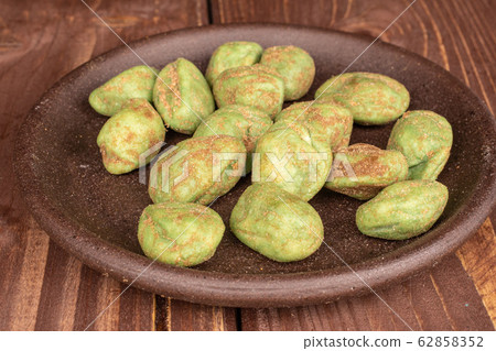 Green wasabi peanut on brown wood 62858352