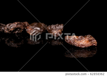 Dried dark raisin isolated on black glass 62858362
