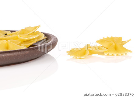 Yellow farfalle pasta isolated on white Yellow farfalle pasta isolated on white 62858370