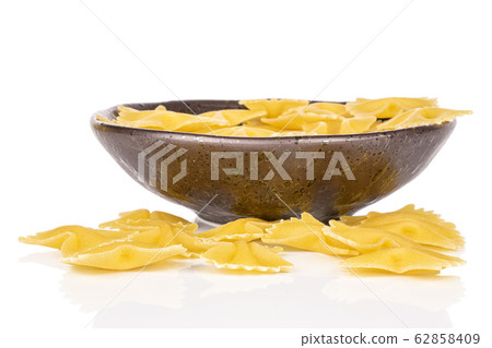 Yellow farfalle pasta isolated on white Yellow farfalle pasta isolated on white 62858409