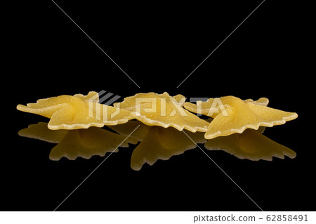 Yellow farfalle pasta isolated on black glass Yellow farfalle pasta isolated on black glass 62858491