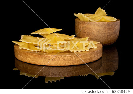 Yellow farfalle pasta isolated on black glass 62858499