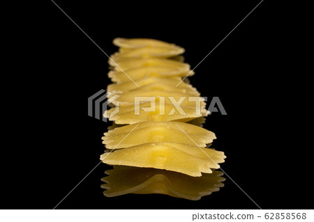 Yellow farfalle pasta isolated on black glass Yellow farfalle pasta isolated on black glass 62858568