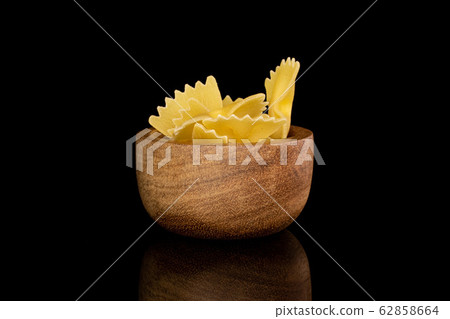 Yellow farfalle pasta isolated on black glass Yellow farfalle pasta isolated on black glass 62858664