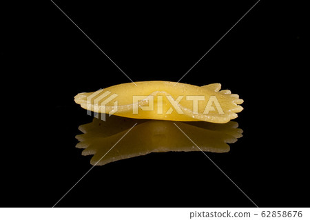Yellow farfalle pasta isolated on black glass Yellow farfalle pasta isolated on black glass 62858676