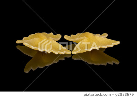 Yellow farfalle pasta isolated on black glass 62858679