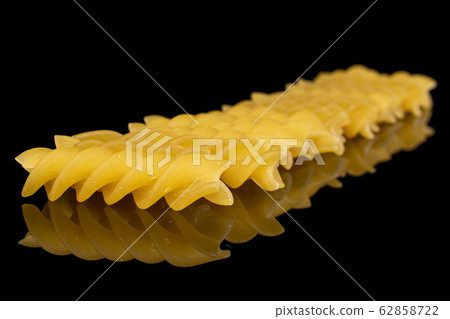 Yellow fusilli pasta isolated on black glass Yellow fusilli pasta isolated on black glass 62858722