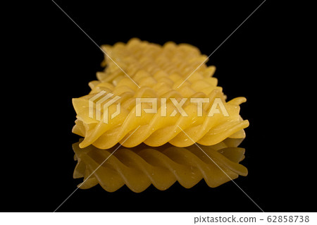 Yellow fusilli pasta isolated on black glass Yellow fusilli pasta isolated on black glass 62858738