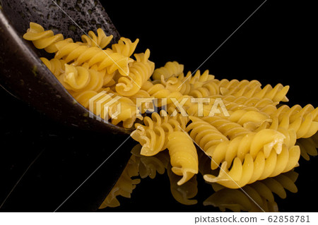 Yellow fusilli pasta isolated on black glass Yellow fusilli pasta isolated on black glass 62858781