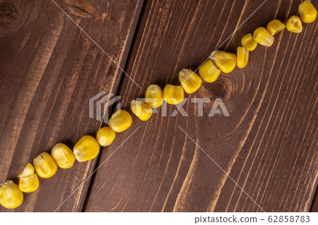 Yellow canned corn on brown wood Yellow canned corn on brown wood 62858783