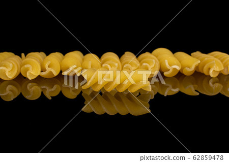 Yellow fusilli pasta isolated on black glass 62859478