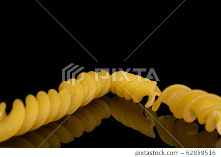 Yellow fusilli pasta isolated on black glass 62859516