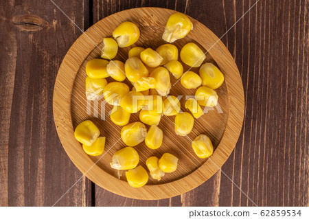 Yellow canned corn on brown wood Yellow canned corn on brown wood 62859534