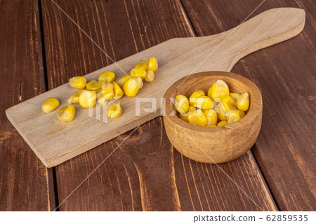Yellow canned corn on brown wood Yellow canned corn on brown wood 62859535