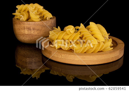 Yellow fusilli pasta isolated on black glass Yellow fusilli pasta isolated on black glass 62859541