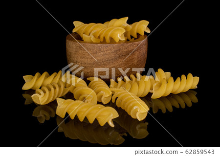 Yellow fusilli pasta isolated on black glass Yellow fusilli pasta isolated on black glass 62859543