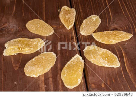Dried yellow pineapple on brown wood Dried yellow pineapple on brown wood 62859643