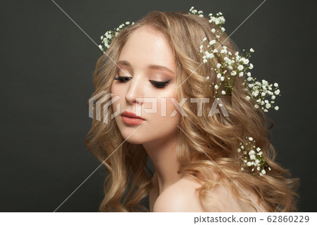 Cute young woman with long healthy curly hair 62860229