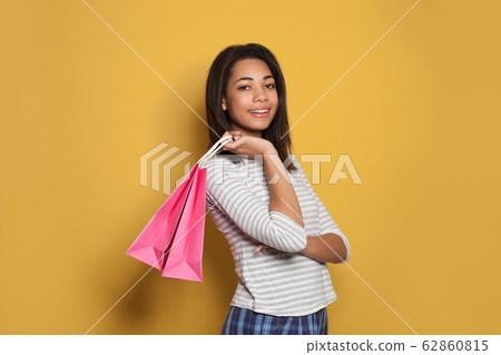 Happy african american woman holding pink shopping 62860815