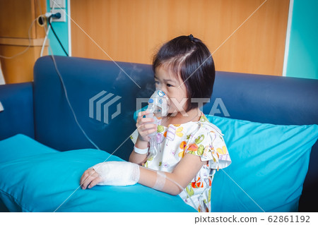 Sad asian child holds a mask vapor inhaler. Sad asian child holds a mask vapor inhaler. 62861192