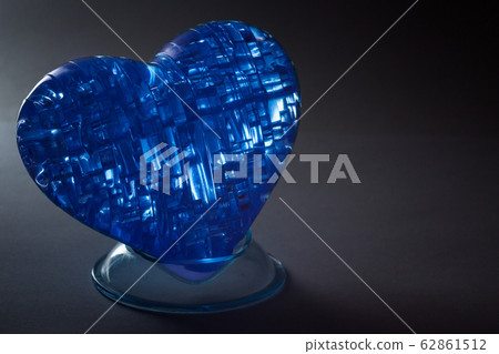 Cold blue heart on a dark background. 62861512