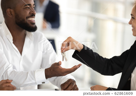 Realtor giving keys to new apartment to african american husband 62861609