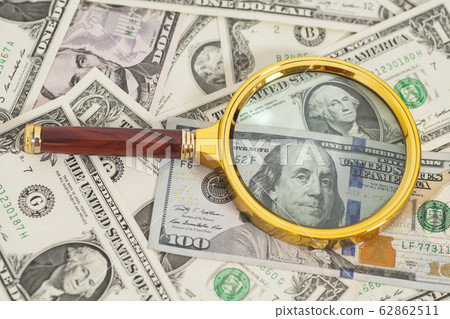 dollar banknotes with magnifying glass 62862511