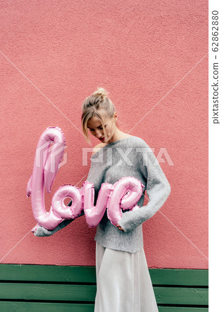 Cute blonde holds a big inflatable word LOVE 62862880
