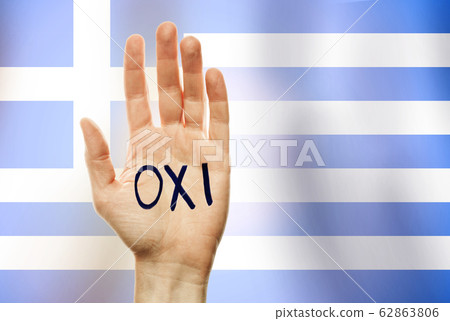 Holiday in Greece. The inscription "OXI" in Greek. Hand raised up on the background of the Greek flag. 62863806