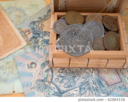 The hoard of old coins in a wooden box 62864138