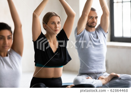 Diverse people meditating during yoga session focus on caucasian woman 62864468