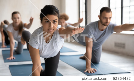 Indian coach and group of people doing Bird Dog Pose 62864482