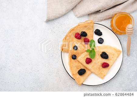 French Crepes With Summer Berries And Honey On Plate French Crepes With Summer Berries And Honey On Plate 62864484