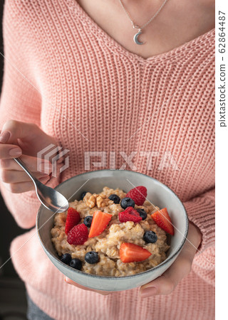 Woman Eating Oatmeal Porridge With Berries, Healthy Breakfast Woman Eating Oatmeal Porridge With Berries, Healthy Breakfast 62864487