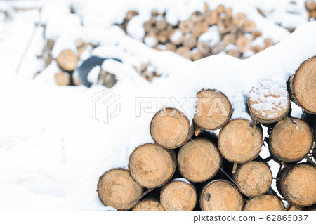 Pile of wooden logs under snow in winter, 62865037