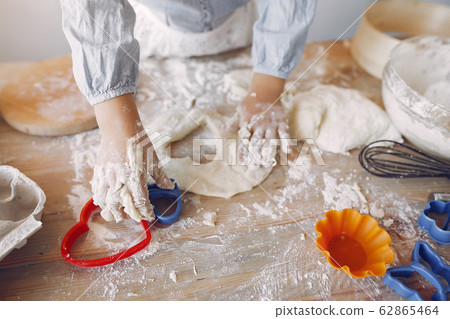Little girl in a white shef hat cook the dough for cookies 62865464