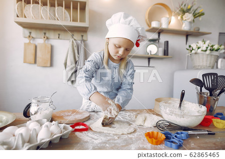 Little girl in a white shef hat cook the dough for cookies 62865465