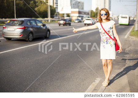 woman standing in the street, calling taxi 62865595
